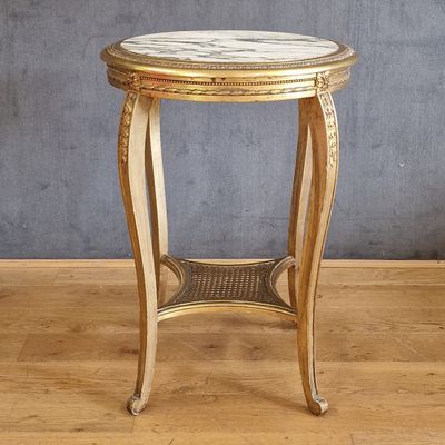 une photo d'une table au plateau en marbre posée sur un parquet