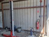 a garage with a red lift in the middle of the floor