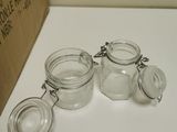 four glass jars with lids on a white table