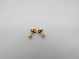 a pair of gold earrings on a white surface