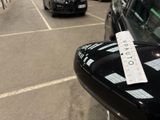 cars parked in a parking lot with a parking ticket attached to the side of the car