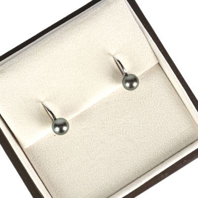 une paire de boucles d'oreilles en perles noires, présentée dans un coffret cadeau sur fond blanc