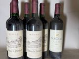 four bottles of red wine are lined up in a row