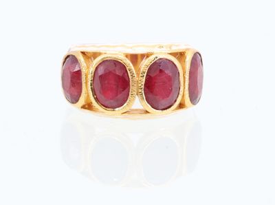 une image représentant une bague en or sertie de pierres rouges sur un fond blanc