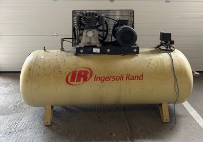 un petit compresseur d'air posé sur un support dans un garage