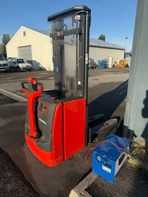 a red and black forklift sitting on the side of the road
