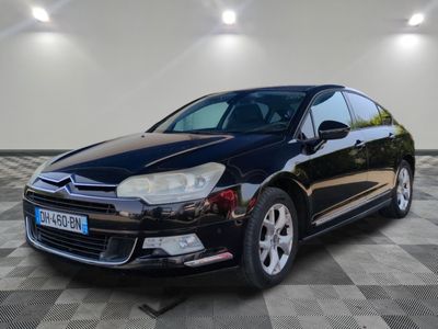 la voiture noire est garée sur un sol en damier dans le garage