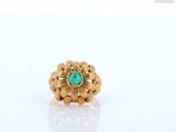 a close up of a gold ring with a green stone
