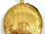 a gold pocket watch on a white surface