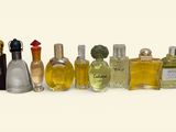 several bottles of perfume are lined up in a row on a white surface