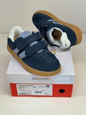 des chaussures pour bébé avec des bandes Velcro et des semelles Velcro, posées sur une boîte