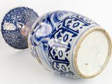 a blue and white vase sitting on a white surface