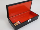 a black box with a red lid on a white surface