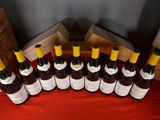 several bottles of wine are lined up on a red table
