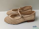 chaussures beiges avec des lanières tressées sur un fond blanc