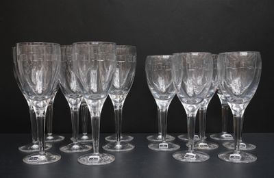 six verres à vin vides alignés sur une table, sur fond noir
