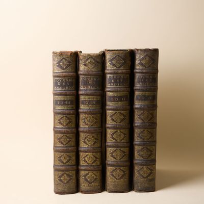 trois vieux livres posés l'un sur l'autre sur une table