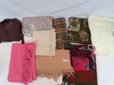 de nombreuses écharpes et foulards étalés sur un lit