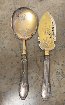 deux cuillères en argent et une cuillère en argent sur une table
