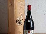 une bouteille de vin posée à côté d'une caisse en bois
