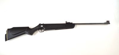 un fusil noir posé sur une surface blanche, avec un fond blanc