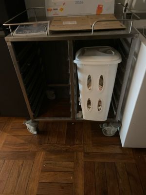 an image of a kitchen with a trash can and a refrigerator