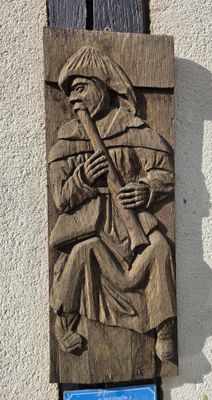 a carving of a man playing a flute on the wall