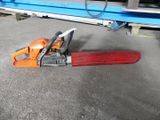 a chainsaw that is laying on the ground next to a piece of wood