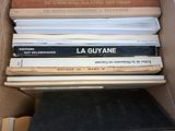 des cartons remplis de livres empilés les uns sur les autres dans une pièce