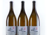 three bottles of wine sitting next to each other on a white surface