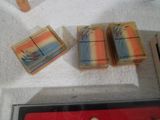 trois paquets de savon posés sur une serviette à côté d'un paquet de savon