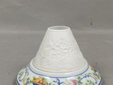 un vase blanc orné d'un motif bleu et jaune