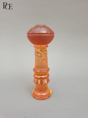 un bougeoir en verre orange sur fond blanc