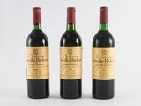 three bottles of red wine sitting next to each other on a white surface