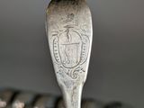 a spoon that is sitting on top of a pile of spoons