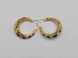a pair of gold hoop earrings on a white surface