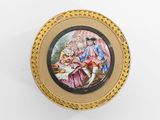 un gros plan d'une petite plaque en or sur laquelle figure une peinture