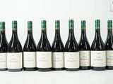 six bouteilles de vin sont alignées sur une table