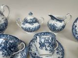 several pieces of blue and white china on a white table