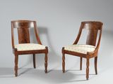 two wooden chairs with upholstered seats and a cushion on the back