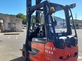 a red forklift truck parked in a parking lot
