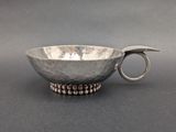 silver bowl with beaded handles and a spoon in the middle