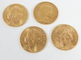 four gold sovereigns on a white surface with a white background