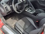 the interior of a red sports car with its door open