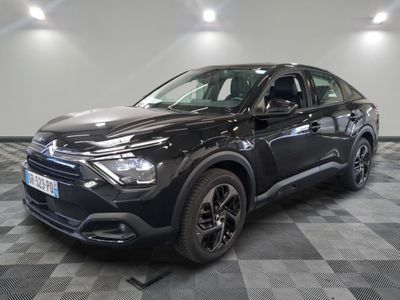 la voiture noire est garée sur un sol en damier dans le garage