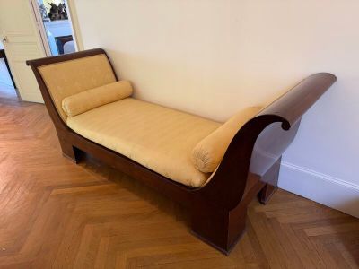 un banc en bois avec un coussin jaune dans un coin de la pièce