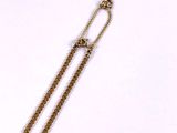 gold plated necklace with a long chain and a pendant with a flower