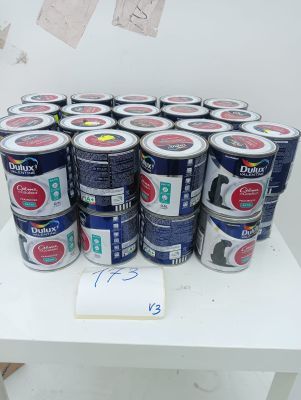 many cans of paint sitting on a white table