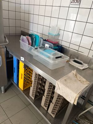 une cuisine équipée d'un plan de travail en inox et d'un réfrigérateur