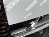 someone is measuring the width of the front bumper of a car
